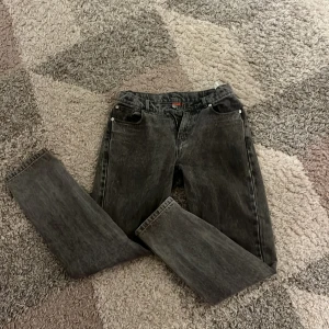 Grå jeans från RYVLS - Snygga grå jeans från RYVLS med en klassisk femficksdesign. De har en rak passform och är perfekta för en avslappnad stil. Jeansen har en diskret tvättad look som ger dem en cool edge.