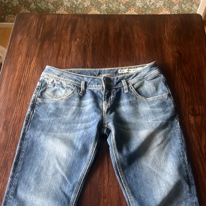 Blå jeans från Hilfiger Denim, Lågmidjade  - Snygga blå jeans från Hilfiger Denim i modellen Nevada Skinny. De har en klassisk femficksdesign och en knappgylf. Perfekta för en stilren look.