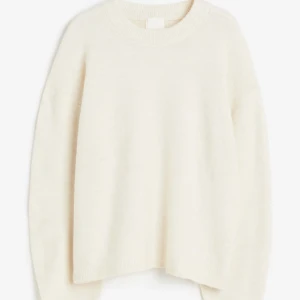 Vit stickad tröja - Säljer en stilren vit stickad tröja med rund hals och långa ärmar. Perfekt för kyligare dagar och enkel att matcha med olika outfits. Ett måste i garderoben för en klassisk look.