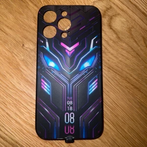 Case  till telefonen🤍 - Snyggt mobilskal med futuristiskt neonmönster i blått och lila. Skalet har ett coolt motiv med lysande ögon och geometriska linjer. Perfekt för att ge din mobil en unik look. När man kopplar telefon och skal ihop då skal lyser.🌟🤍