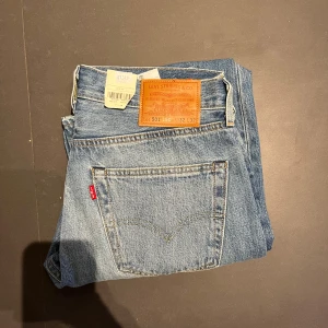 Helt nya Levis 501 jeans i ljusblå denim - Snygga Levis 501 jeans i ljusblå denim med klassisk femficksdesign. De har en straight passform och slitna detaljer på framsidan för en trendig look. Perfekta för en avslappnad stil. Nypriss 1349 mitt endast 500. 
