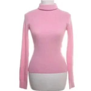 Rosa turtleneck tröja - Snygg rosa turtlenecktröja med långärmad design. Perfekt för kyligare dagar och ger en stilren look. Tröjan har en tight passform som framhäver figuren.