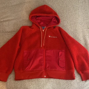 Röd teddyjacka från Champion - Säljer en röd teddyjacka från Champion🔥  Jackan har två stora fickor framtill  och är i gott skick. Den är mjuk och bekväm med en sportig look.