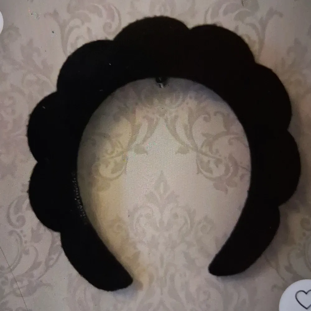 Elegant svart diadem med en unik vågig design. Perfekt för att ge en stilfull touch till din outfit. Passar bra för både vardag och speciella tillfällen.. Asusteet.