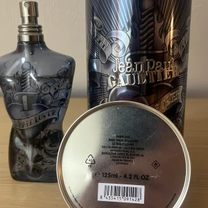 Le Male Le Parfum från Jean Paul Gaultier - Säljer en flaska Le Male Le Parfum från Jean Paul Gaultier. Flaskan har en unik design i form av en manlig torso i mörkgrått glas med tatueringsinspirerade detaljer. Parfymen kommer i en metallisk cylinderförpackning med matchande design. Flaskan rymmer 125 ml och det är kvar cirka 110-115 ml. Parfymen är ganska sällsynt och finns inte överallt köpte för 1200kr sälj för 899kr