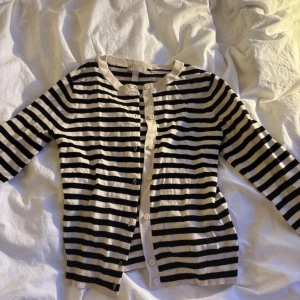 Randig kofta från H&M - Säljer en randig kofta från H&M i svart och beige. Koftan är iprincip oanvänd då den är lite för liten för mig. 