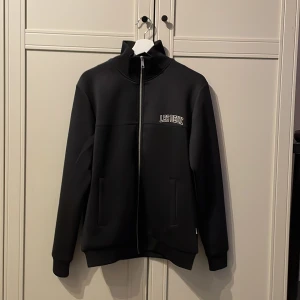 Svart tröja från Les Deux - Snygg svart tröja från Les Deux med dragkedja. Perfekt för en stilren look. Riktigt bra skick nästan aldrig använd. Pris kan diskuteras. TAR ÄVEN BYTEN!!!