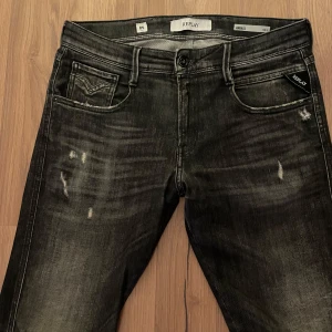 Replay Anbass jeans  - Riktigt snygga svarta Replay anbass jeans med slitningar. Säljs inte längre och är därmed väldigt eftertraktade jeans. Storlek är 30/34 men sitter som mer som 30/32. Pris är absolut inte hugget i sten, så kom med förslag. Lite öppet vid slitningen vid knät men syns knappt, fråga om bild om du undrar