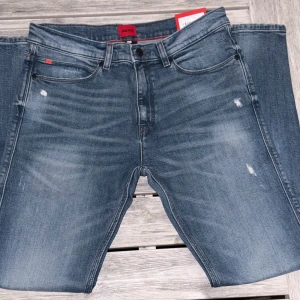 Blå HUGO Jeans - Riktigt trendiga & moderna Jeans, HUGO 708. Super bra kvalitet och håller otroligt länge! Helt oanvända & Kommer i sitt orginal förpackning med lappar osv. NYPRIS: 1500kr