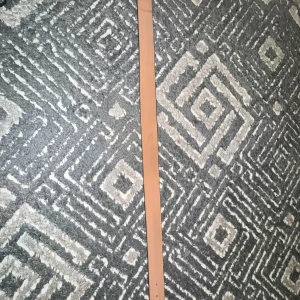 Brunt rutigt bälte med svart spänne - Snyggt bälte med ett klassiskt rutigt mönster i brunt och svart. Bältet har ett stilrent svart spänne som ger en modern touch. Perfekt för att lyfta vilken outfit som helst.