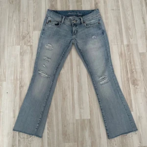 Ljusblå jeans från American Eagle - Snygga ljusblå jeans från American Eagle med slitningar. De har en bootcut-stil och är väldigt lågmidjade,  skriv gärna om ni undrar om mått eller så💞🫰🏼