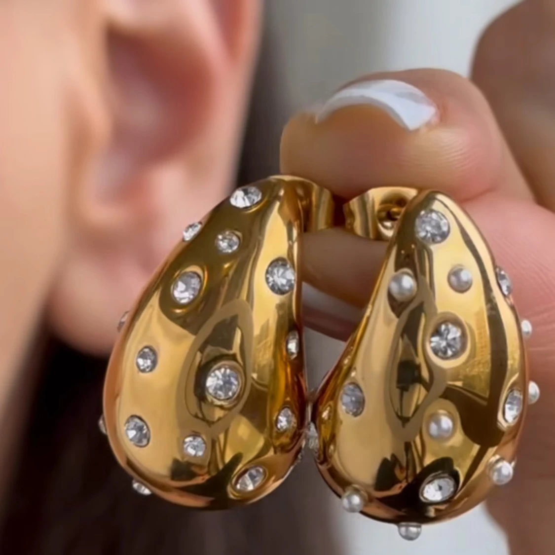 Guldörhängen med glittriga stenar