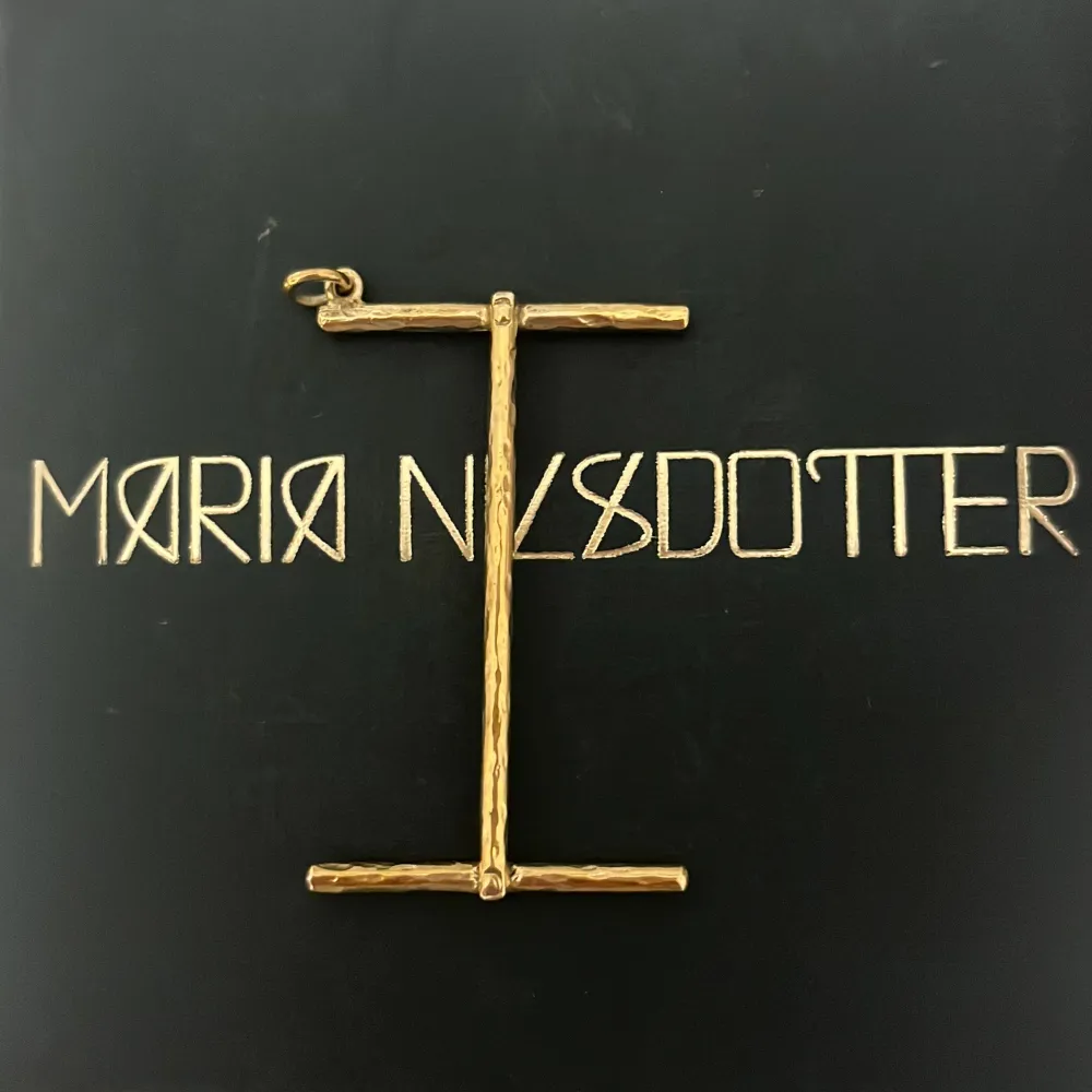 I berlock frĂ„n Maria Nilsdotter i guldđ„°. Asusteet.