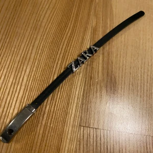 Svart armband med silverdetaljer - Snyggt och stilrent svart armband med silverdetaljer. Perfekt för både vardag och fest. Armbandet har en smal design och är lätt att matcha med andra smycken. 