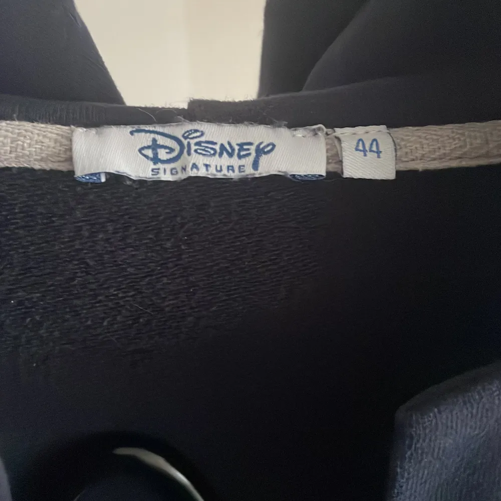 Säljer en mörkblå jacka från Disney Signature i storlek 44. Jackan har långa ärmar och knappar framtill. Den är dekorerad med ett diskret broderi och har en knytning i midjan. Perfekt för höst och vår!. Jackor.