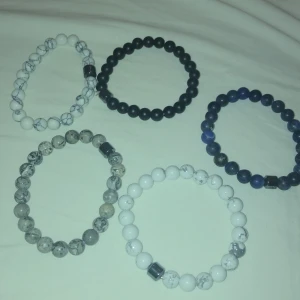 Stilrena pärlarmband i olika färger - Säljer fem snygga pärlarmband i olika färger. De är elastiska och passar perfekt för både vardag och fest. Färgerna är svart, blå, vit och grå, med en cool marmoreringseffekt på vissa av dem. Perfekt accessoar för att ge din outfit det lilla extra!