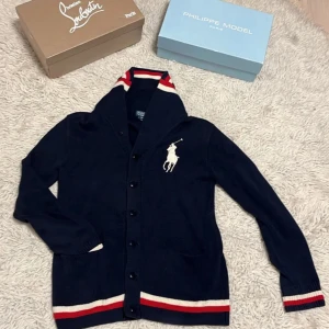 Mörkblå kofta från Ralph Lauren - Säljer en snygg och unik mörkblå kofta från Ralph Lauren. Den är helt ny nästan och i väldigt fint skick. Modellen på bilden är 182 och väger 57kg. Skriv om ni har några frågor eller funderingar/Vilgot!