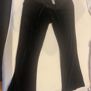 Svarta byxor från Juicy Couture - Snygga svarta byxor från Juicy Couture i mjukt material. Det i ok skick då dem är vintage och materialet är ganska strävt. Säljer dem då dem var för korta på mig, ( är 1,67), passar personer som är runt 1,60 och neråt. Sömmen har gått upp lite på ena fickan men kan lätt fixas hos skräddaren.