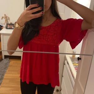 Blus - Jättesöt röd blus i bra skick. Den har en säkerhetsnål på ryggen eftersom knappen inte går att använda. 