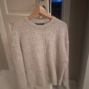 Grå stickad tröja från BikBok - Mysig grå stickad tröja från BikBok i bra skick. Perfekt för kyliga höst- och vinterdagar. Tröjan har en avslappnad passform med långa ärmar och en rund halsringning. Den är superbekväm och lätt att matcha med olika outfits. Perfekt för både vardag och mysiga hemmakvällar!