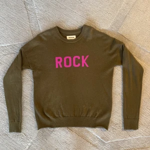 Zadig & Voltaire - olivgrön stickad tröja  - Olivgrön stickad tröja med ribbstickade muddar och detaljen  ROCK på bröstet. I stort sett oanvänd och säljs för att den är för liten. 