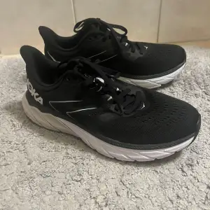 Säljer ett par svarta Hoka sneakers i mycket bra skick. De har en bekväm och dämpad sula, perfekt för träning eller vardagsbruk. Skorna har snörning och en stilren design med vita detaljer. Passar perfekt för dig som vill ha både stil och komfort. Bandet mitt  på skon har  lossnat på båda men påverkar  inte  funktionen ,  små  stl skulle säga 37,5