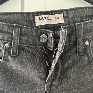 Grå jeans från Lee - Säljer ett par snygga grå jeans från Lee i mycket bra skick. De har en klassisk femficksdesign med dragkedja och knapp framtill. Perfekta för både vardag och fest! 🖤