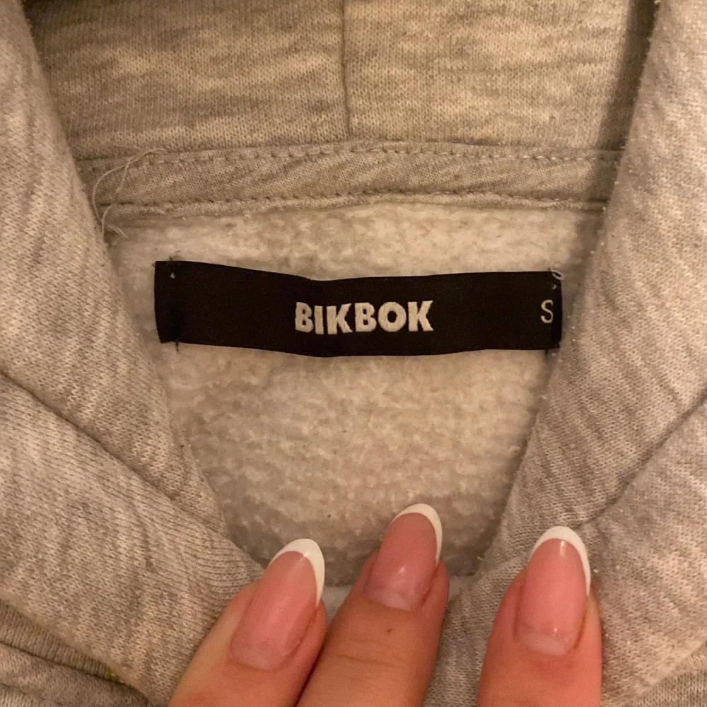 Säljer en supermysig grå hoodie från BikBok i storlek S. Perfekt för kyliga dagar med sin mjuka insida och klassiska design. Den har en praktisk ficka framtill och justerbar huva. Passar både till vardags och mysiga hemmakvällar. 🩶. Hoodies.