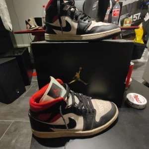 Nike Air Jordans i svart och röd - Säljer ett par klassiska Nike Air Jordans i svart och röd. Skorna har en snygg design med svart snörning och den ikoniska Air Jordan-loggan. Perfekta för både vardag och fest. De är i bra skick och redo för nya äventyr!
