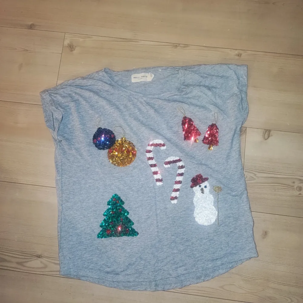 Grå t-shirt från Lindex med med julmotiv i paljetter. Den är endast använd 2 gånger så den är i väldigt bra skick. Perfekt för julfirandet! Storlek 158/164. T-shirts.