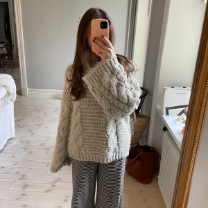 Oversized kabelstickad tröja - Supermysig och varm kabelstickad tröja från NA-KD i storlek XXS/XS. Jag på bilden är 1,60 lång, och på mig är passformen oversize. Endast använd ett fåtal gånger, och är i mycker fint skick! Tveka inte att kontakta mig vid frågor eller för fler bilder 🧶✨