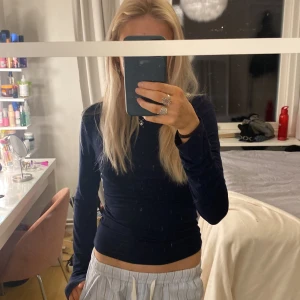 Mörkblå långärmad topp - Säljer en snygg mörkblå långärmad topp i ett stretchigt material. Den är från Gina strl xs