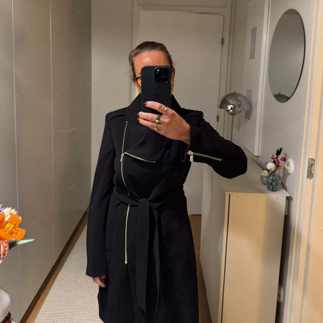 Svart kappa med dragkedjor i guldfärg