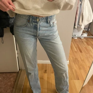 Ljusblå jeans - Säljer ett par ljusblå jeans i mycket bra skick. De är midwaist med en straight passform och klassisk femficksdesign. Perfekta för både vardag och fest! 🦋(de är slitna vid dragkedjan syns på bild, men går nog lätt att fixa) 