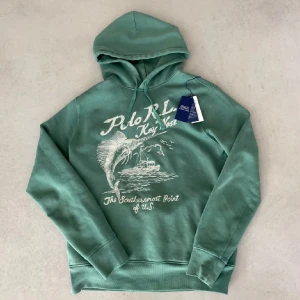 Grön hoodie Ralph Lauren - Säljer en snygg grön hoodie från Polo Ralph Lauren i storlek M. Den är i oanvänt skick, endast testad. Storlek M men passar även S. Nypris runt 3000kr.