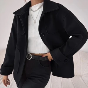 Svart kappa - Säljer en stilren svart kappa i mycket bra skick. Den har en klassisk krage och knappar framtill. Perfekt för höst och vår, med en normal passform som funkar till alla outfits. Ärmarna är långa och materialet känns mjukt och bekvämt. En tidlös jacka som är ett måste i garderoben! Storlek S