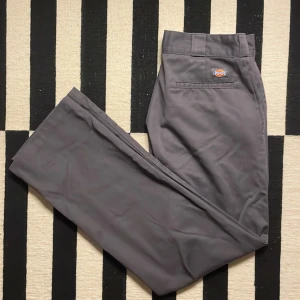 Mörkgråa byxor från Dickies, storlek 32/32 - Eftertraktade mörkgråa Original Fit 874 Dickies byxor i storlek W32/L32. Byxorna är i nyskick. Perfekta byxor för en vanlig vardag eller för finare tillfällen. Nypris: 800kr