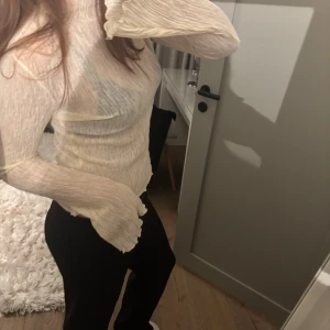 Beige ribbad topp - Säljer en superfin beige ribbad topp med långa ärmar. Den är perfekt för både vardag och fest, och har en skön passform som sitter snyggt på kroppen. Toppen är i ett mjukt och stretchigt material som gör den bekväm att bära hela dagen. Prislapp kvar 