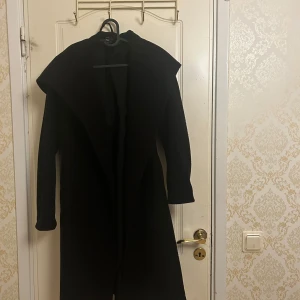Kappa med huva - Svart kappa med huva , fickor och skärp. Använts få gånger. 