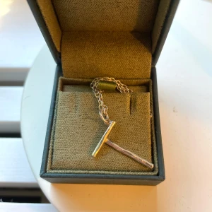 Maria Nilsdotter halsband - Maria Nilsdotter halsband i bokstaven T, fint skick längd på halsbandet är 50cm man kan få antingen den tunna kedjan eller en tjock om man skulle vilja 💕