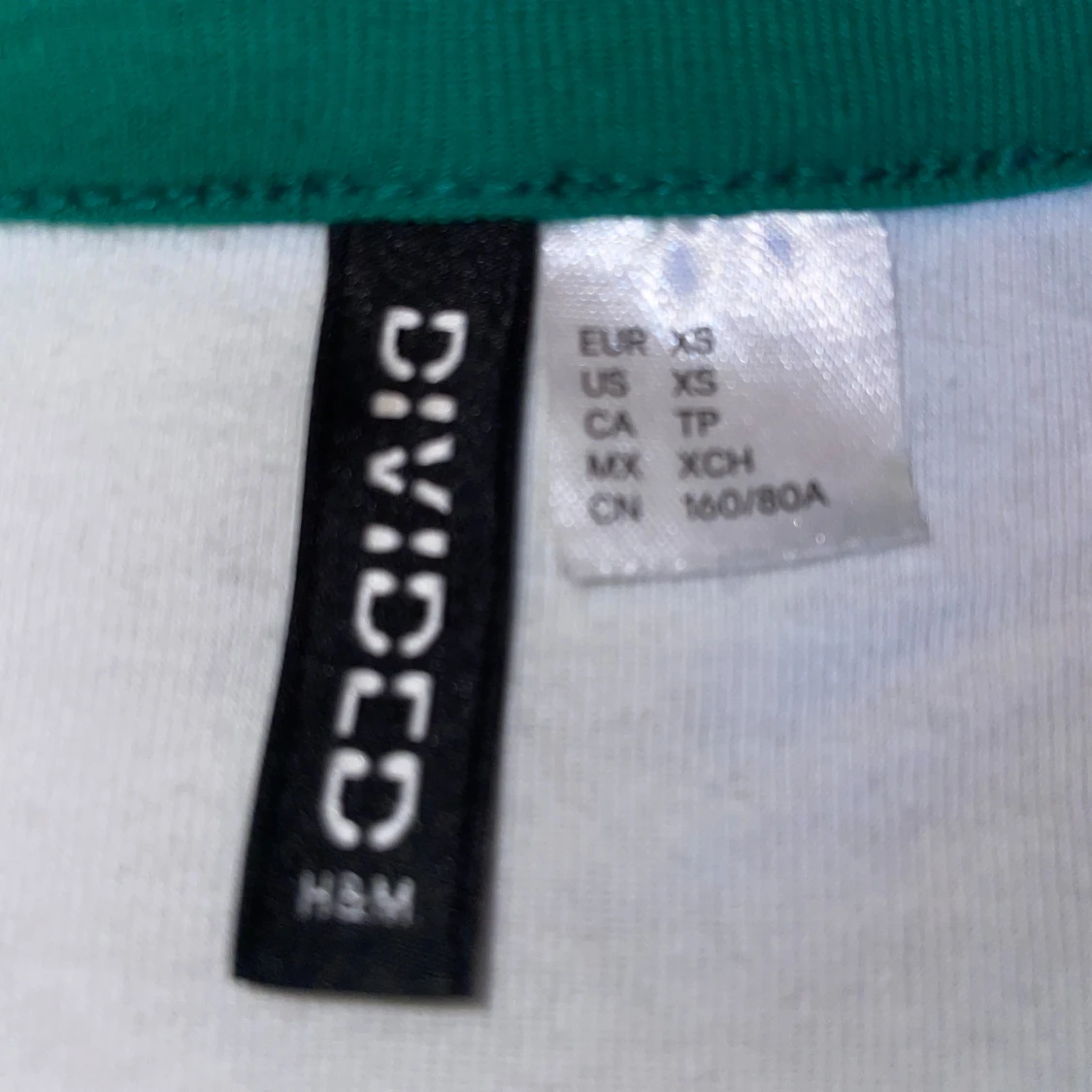 Vit T-shirt med gröna ”kanter” och rosa tryck. - 90