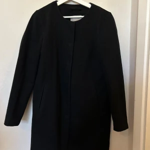 Svart rak kappa Vero Moda S/M - Svart medellång kappa från Vero Moda. Rak och stilren modell. Storlek M, men liten i storlek. Skulle säga mer XS/S.  Sparsamt använd och i mycket bra skick.