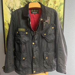 Barbour ”Union Jack” Vaxjacka - En otroligt snygg och stilren jacka! Ett riktigt fynd dessutom! Storlek M, Inköpt för 7700kr. Nyvaxad, kommer med tillbehöret som syns i bilden. Populäraste Union Jack international modellen. Kan även hämtas i Sigtuna. Tveka inte att fråga om något.