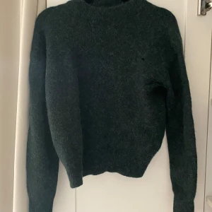 Samsøe Samsøe ulltröja - Mörkgrön ulltröja från Samsøe Samsøe. Har ett litet hål på bröstet (se bild), kan lätt sys igen eller täckas med texilmärke.  