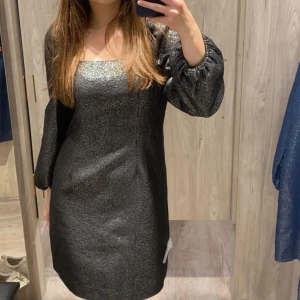 silvrig klänning - silvrig klänning, aldrig använd och har fortfarande lappen kvar. har puffiga ärmar och insydd midja.