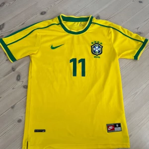 Fotbollströja - En ursnygg Brasilien tröja! Tröjan är äkta, se bild 5. Tröjan är i bra skick, däremot några små små fläckar som knappt syns(därav priset) Hör av dig vid minsta fundering!💛💥