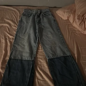 Tvåfärgade jeans med hög midja. Är lite baggy. - Snygga tvåfärgade jeans med hög midja. De har en ljusare denim upptill och mörkare denim nedtill, vilket ger en cool kontrast. Klassisk femficksdesign med knapp och dragkedja framtill.