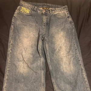 Blå jeans med drakbroderi från Ed Hardy - Säljer ett par coola blå jeans från Ed Hardy, dom är lite blåare i verkligheten köpte på Urban Outfiters    Size 32 W  32 L 