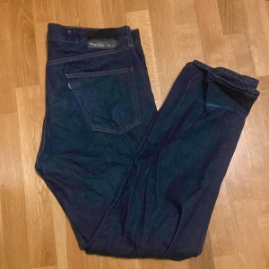 Mörkblå jeans från Levi's - Säljer ett par mörkblå Levi's jeans, modell 551Z Authentic Straight. Klassisk design med fem fickor och knappgylf. Perfekta för en avslappnad stil. Skick 7/10 säljer för endast 149!