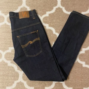 Mörkblå jeans från Nudie Jeans Co  - Använda 1 gång Storlek w32L32 men passar även W30 Mörk blå jeans från nudie jeans co. Ny pris är 1700 kr. De är slim fit passar som ett par replay anbass ungefär. Pris går att diskutera vid snabb affär 